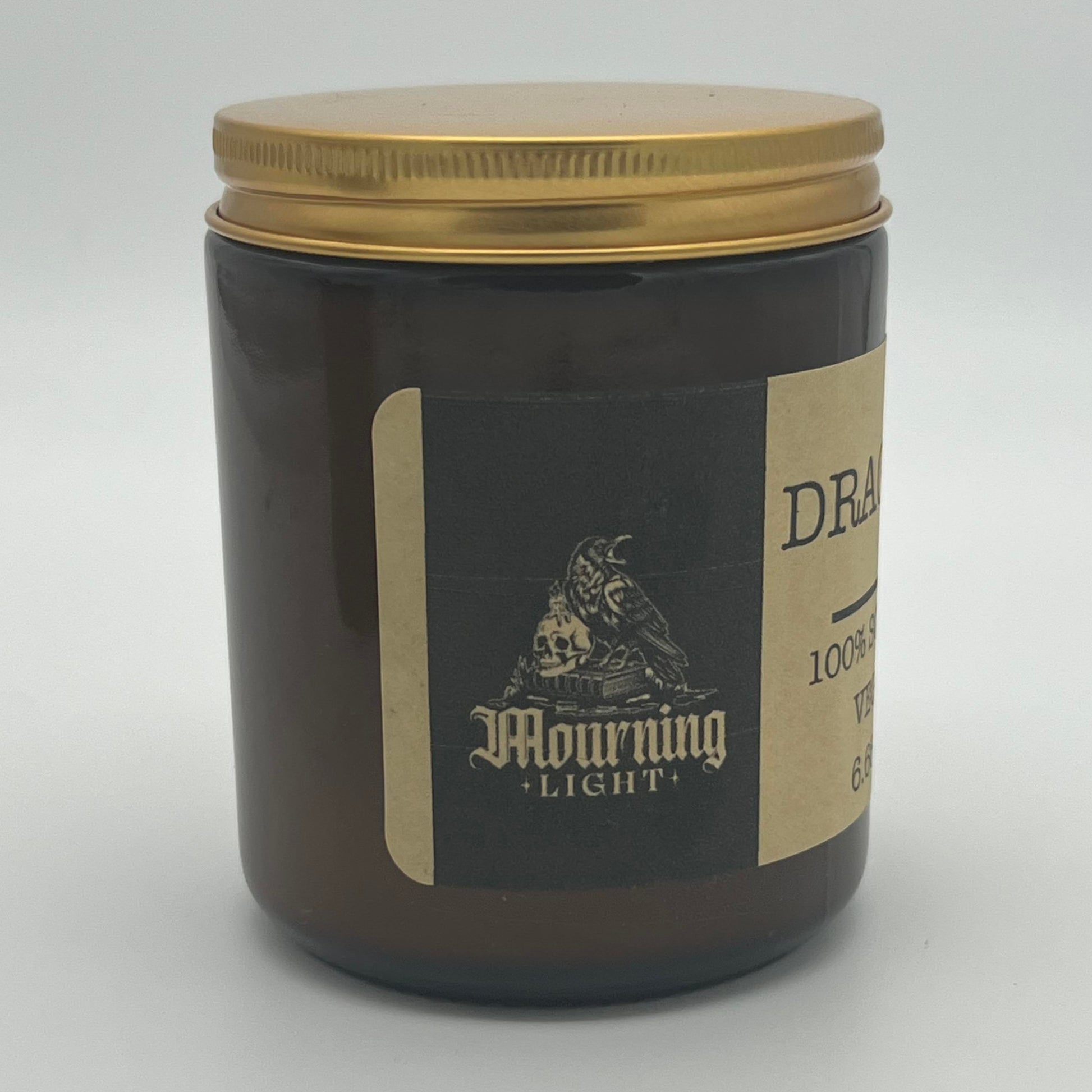 Amber jar with In Mourning's Mourning Light label on a white background